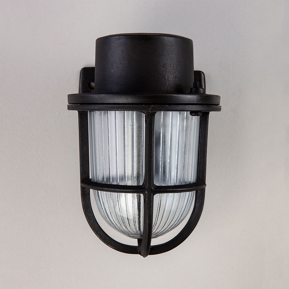 A black Faros Mini Yacht wall light with a clear glass shade by Old School Electric.